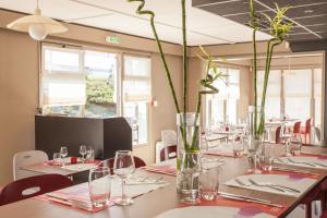普瓦捷普瓦捷钟楼酒店的用餐室配有带眼镜和花瓶的桌子