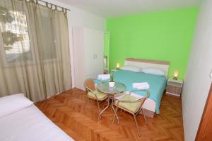 伯德古拉瓦登诺威公寓酒店的配有一张床和一张桌子及椅子的房间