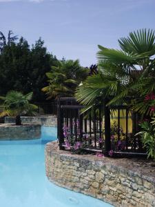 福梅尔Domaine De Guillalmes的种满鲜花和棕榈树的度假村的游泳池