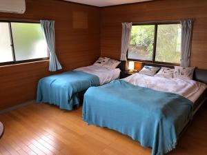 小豆岛villa chillon的带2扇窗户的客房内的2张床
