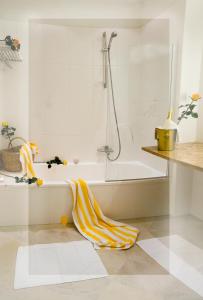 巴德小基希海姆松纳尔姆酒店的铺有白色的浴室,浴室内配有浴缸和毛巾。