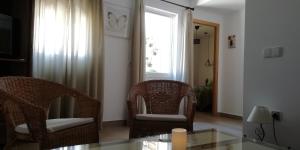 埃尔加斯托尔El Duende del Tejar的客厅配有两把椅子和一张玻璃桌