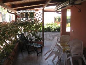 帕利努罗Casa Vacanze Mimose的庭院配有桌椅和桌椅