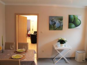 奥斯特巴特宁哈根Modern Apartment in Nienhagen with Terrace, Garden, Barbecue的一间用餐室,配有一张桌子和两幅墙上的画作
