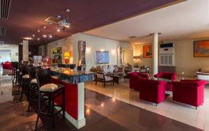 米多恩Cesar Thalasso的一间设有红色椅子的餐厅和一间位于客房内的酒吧