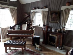 赫克瑟姆Thornley House的客厅配有钢琴和壁炉