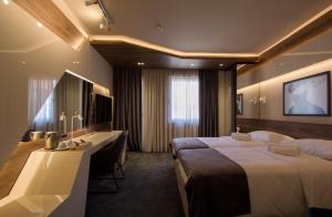 尼什Garni Hotel Boutique 25h的酒店客房设有两张床和电视。
