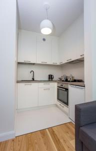 比亚韦斯托克CR Kameralny Apartament przy Pałacu Branickich的厨房配有白色橱柜和水槽