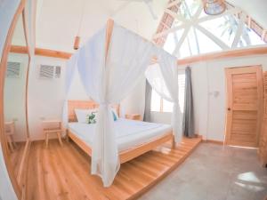 锡基霍尔Bermuda Triangle Bungalows的一间卧室配有一张带蚊帐的床