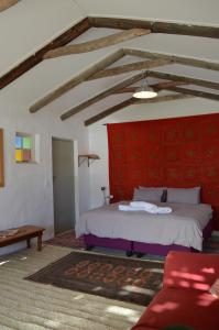 斯坦福Laughing Waters Farm的一间卧室设有一张床和红色的墙壁