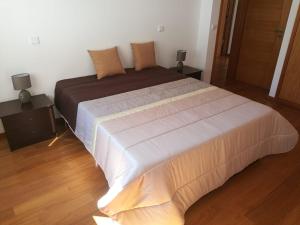 吉马良斯Casa Carla的一张大床,位于带2个床头柜的房间