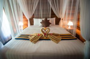 珀尼达岛Ruji Ananta Cottage的一间卧室配有一张床,上面有两条毛巾