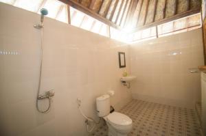 珀尼达岛Ruji Ananta Cottage的一间带白色卫生间的浴室和窗户。