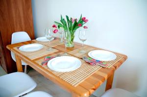波别罗沃Apartament IKAR blisko morza的桌子,桌子上放有盘子,酒杯,花瓶