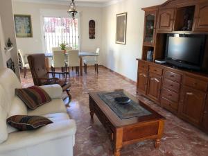 托雷德尔马尔Casa de la Colina的带沙发、电视和桌子的客厅