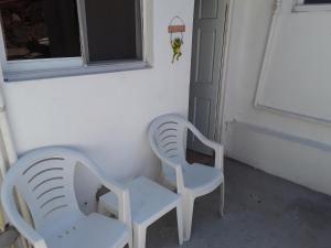 海地角Pablo Guess House的两把白色椅子坐在窗边