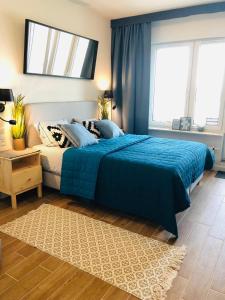米兹多洛杰Aquamarina Onyx Blue的一间卧室设有蓝色的床和2个窗户。