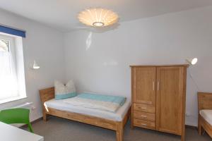 德雷施维茨Haus Residence的一间卧室配有一张床和一个木制橱柜