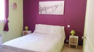 波尔蒂乔Villa Les hauts de Benista的卧室配有白色的床和紫色墙壁