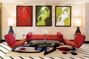 马斯帕洛马斯海滨棕榈滩酒店的客厅配有红色的沙发和两把椅子