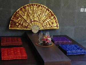 金巴兰巴厘岛金象精品别墅的一张带风扇的桌子和一些红色和蓝色的座椅