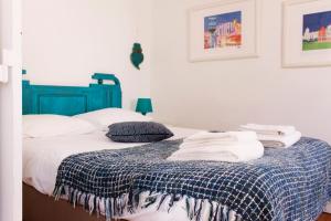 里斯本Like Home by Madrabica的一张带蓝色床头板和毛巾的床