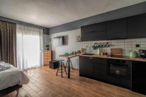 克桑西LP Luxury Citycenter Studio的一间厨房,配有黑色橱柜和一张位于客房内的床