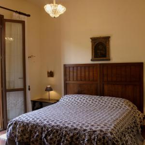 科尔莱奥内Agriturismo Ridocco的一间卧室配有一张大床和一个吊灯。
