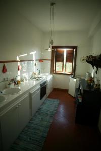 科尔莱奥内Agriturismo Ridocco的白色的厨房设有两个水槽和窗户