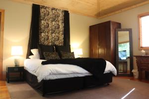 丹德农山林登花园雨林住宿加早餐旅馆的一间卧室配有一张带黑白毯子的床