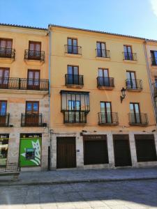 罗德里戈城Alojamiento Samumari的一座大型黄色建筑,位于街道上,设有阳台