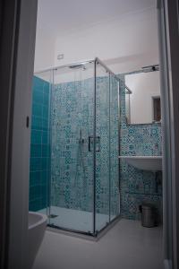 拉维罗La Gemma di Ravello的浴室设有蓝色瓷砖玻璃淋浴间