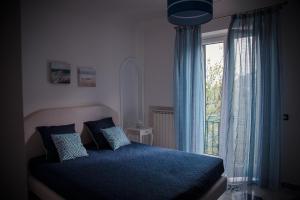 拉维罗La Gemma di Ravello的一间卧室设有蓝色的床和窗户。