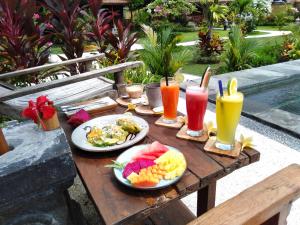艾湄湾Kubu Kangin Resort的一张木桌,上面放着食物和饮料
