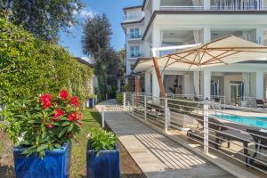 马里纳-迪-皮特拉桑塔中央公园酒店的一座带游泳池、遮阳伞和鲜花的房子