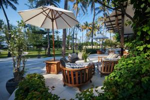 吉利特拉旺安彭杜克桑蒂酒店的一个带椅子和遮阳伞的庭院,棕榈树