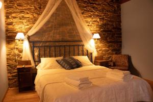 LourenzáCasa Rural Norita - Adults only的一间卧室设有一张带石墙的大床