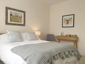 红山1 Ashford Road Guesthouse的卧室配有白色的床和书桌