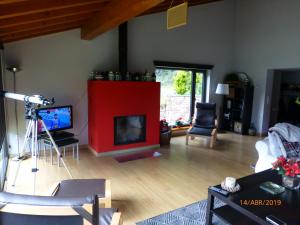 奥耶多La Riega del Peral的客厅设有红色壁炉和电视。
