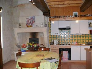 圣艾米隆Les Oiseaux的一间带桌子的厨房和一个带壁炉的厨房