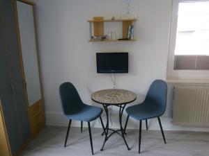克伦胡森Haus Steinbach的一张桌子和两把椅子,以及客房内的一台电视机