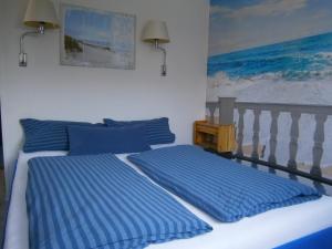 克伦胡森Haus Steinbach的一间卧室配有两张带蓝色枕头的床