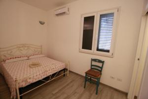 新福卡Villa Maria Holiday House的卧室配有床、椅子和窗户。