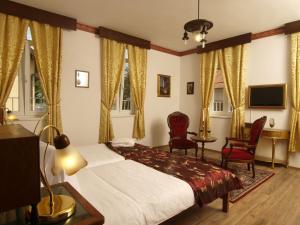 萨格勒布庞迪加酒店的一间卧室配有一张床、两把椅子和电视