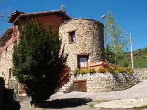 Santiurde de ReinosaAlbergue La Torre的前面有棵树的石头房子