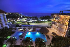 埃斯孔迪多港Hotel Caracol Plaza的享有酒店的景色,在晚上设有游泳池