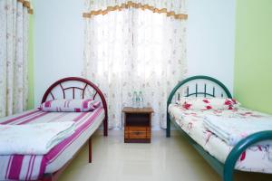 龙运Anjung Nor Muslim Homestay的一间卧室配有两张床和一张桌子