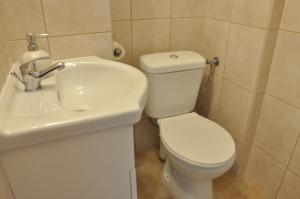 波兹南Flinstones的浴室配有白色卫生间和盥洗盆。