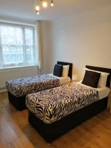 伦敦Dream Time Apartments-Aqua Suite的两张睡床彼此相邻,位于一个房间里