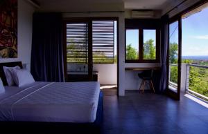 乌鲁瓦图乌鲁瓦图阿万别墅的卧室配有一张床、一张书桌和窗户。